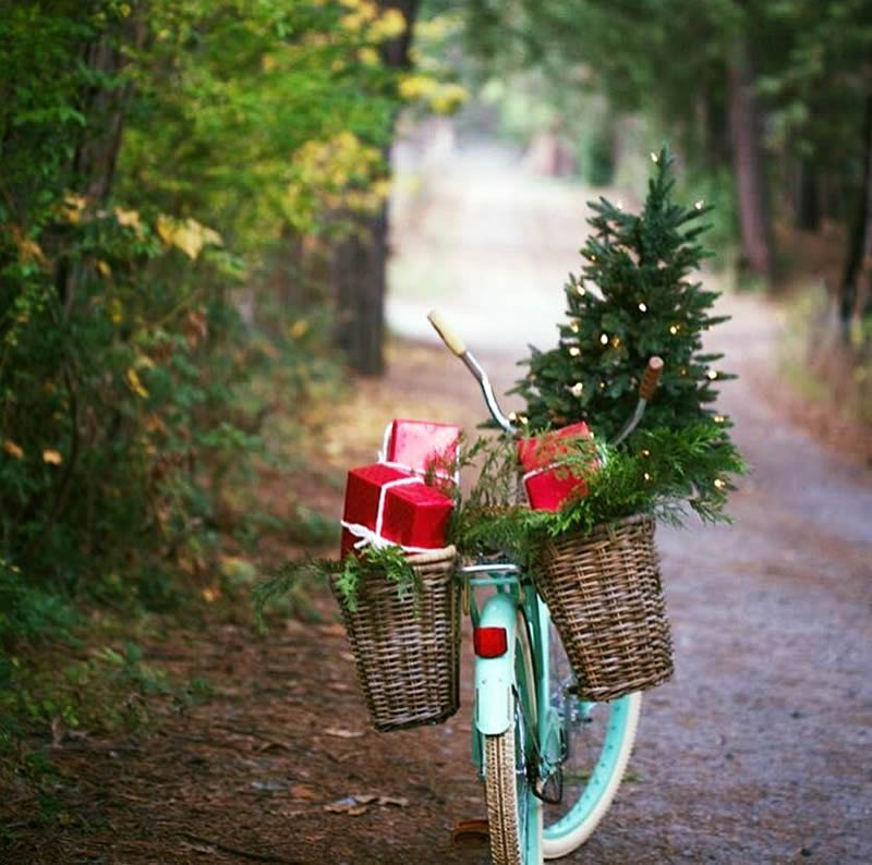 Immagine di Natale con una bicicletta che trasporta un albero di Natale e regali.