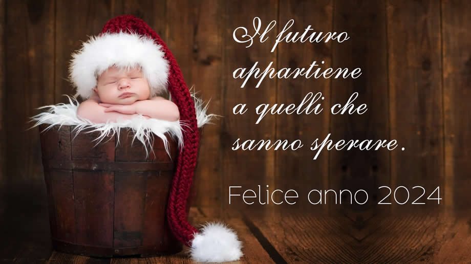 Immagine con un meraviglioso bambino vestito da babbo natale in posa in una botte con messaggio di auguri: Il futuro appartiene a quelli che sanno sperare