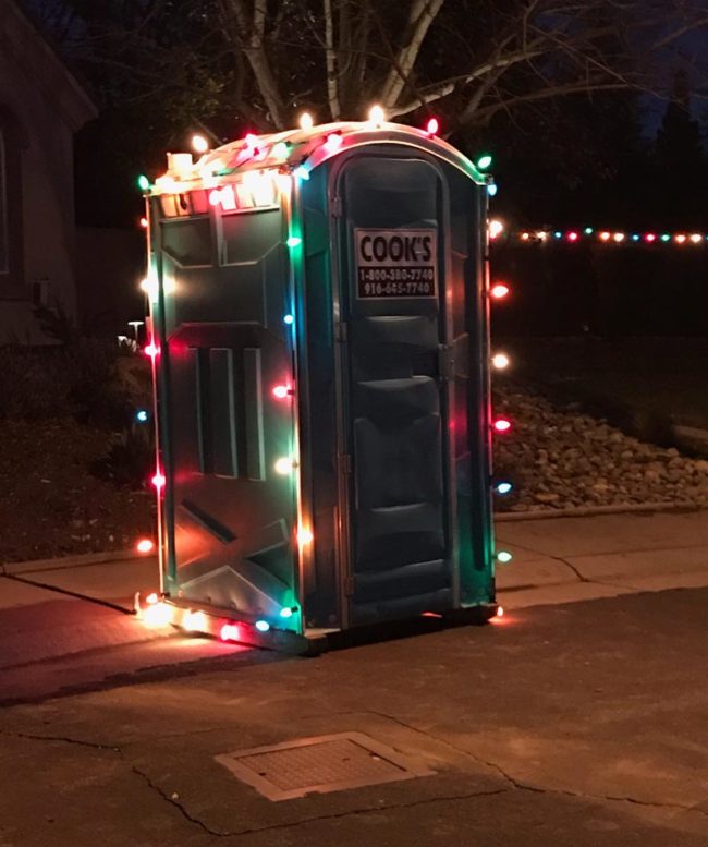 Un bagno chimico per cantiere decorato da luci colorate di Natale, è Natale per tutti
