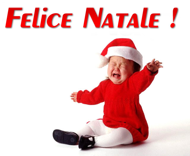 Una bambina che piange disperatamente con il vestito di Babbo Natale. Con testo: Felice Natale